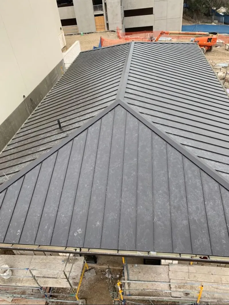 Commercial metal roof construction with crane equipment in Pomona